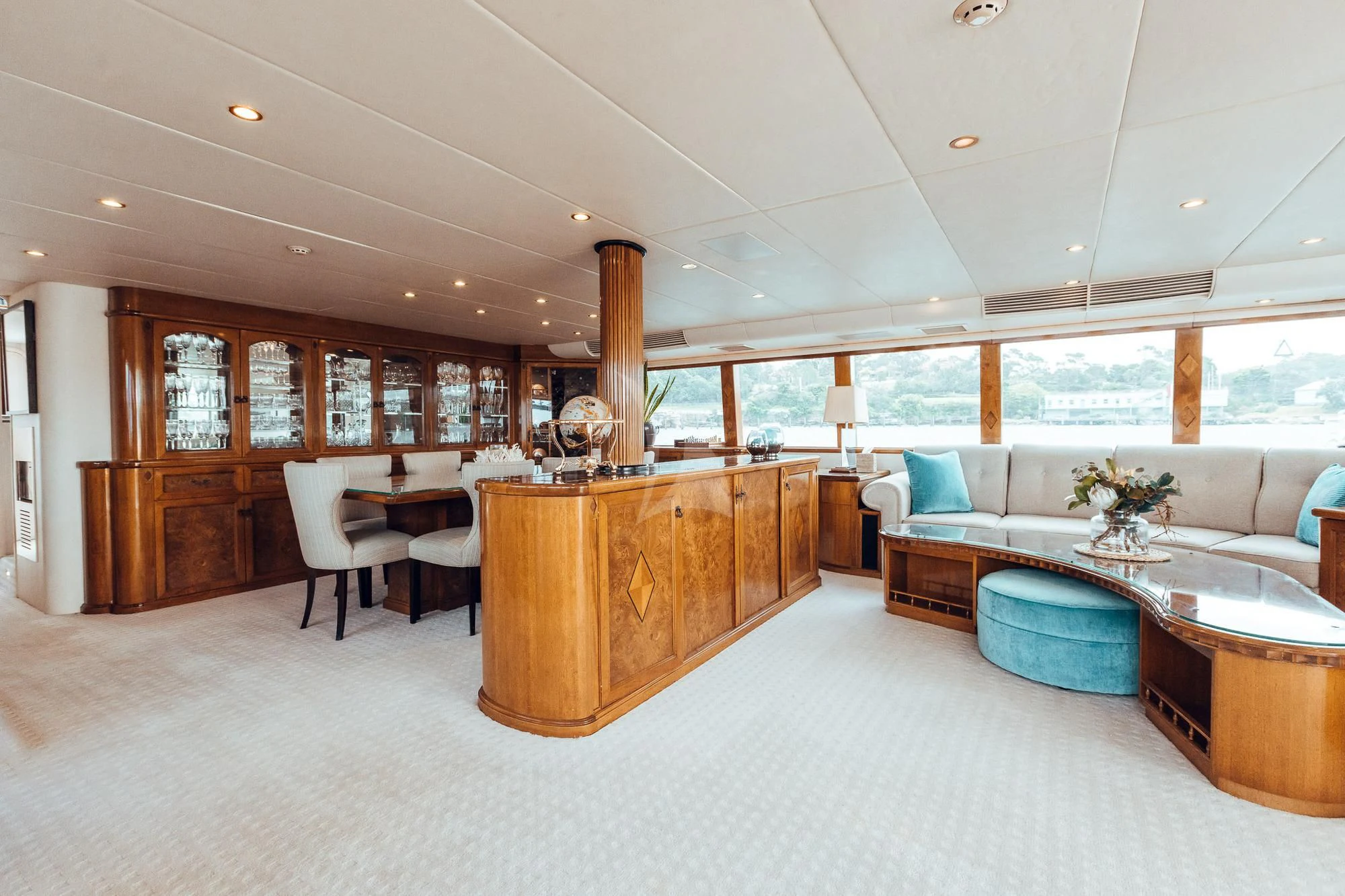 a large living room with a large wood cabinet and a large window aboard OSCAR II Yacht for Sale
