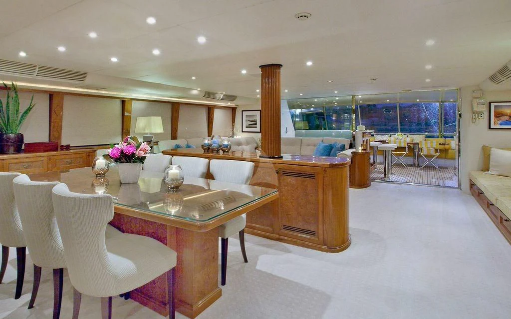 a large room with a table and chairs aboard OSCAR II Yacht for Sale