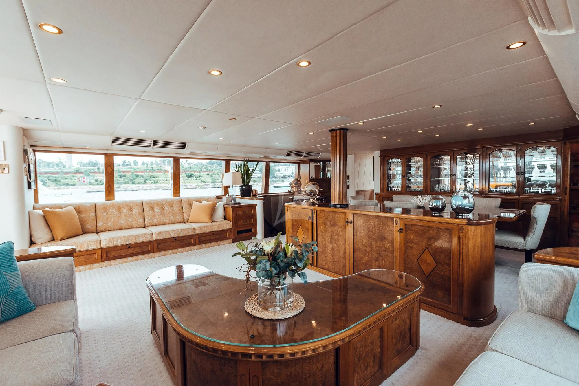 a living room with a table and couches aboard OSCAR II Yacht for Sale