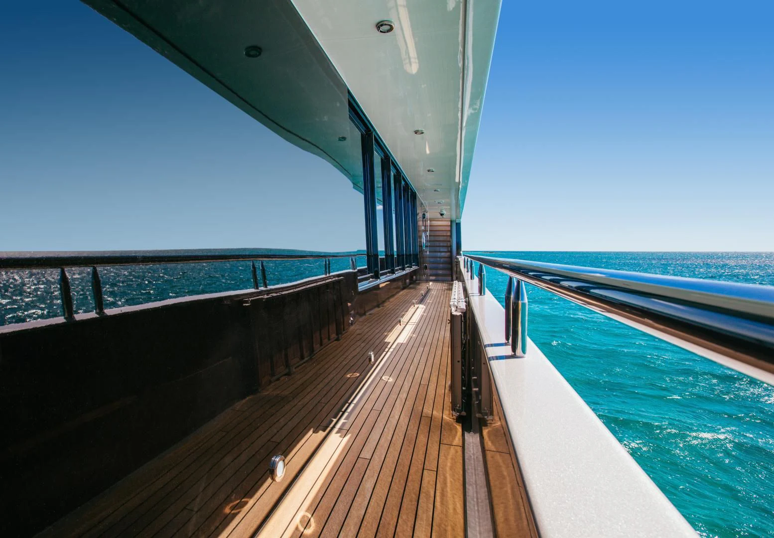 a wooden walkway over a body of water aboard STARSHIP Yacht for Charter