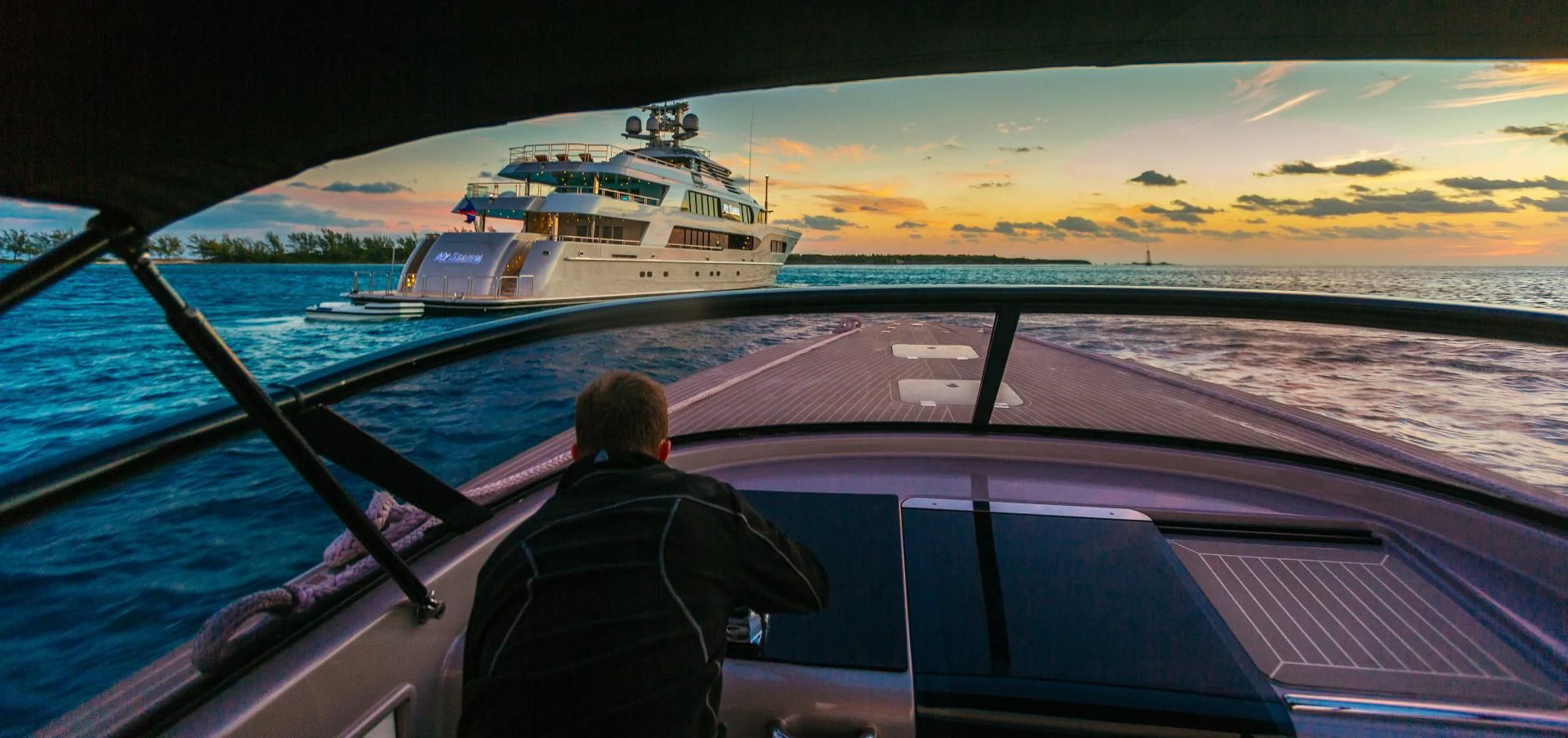 a person sitting in a car looking at a ship in the water aboard STARSHIP Yacht for Charter