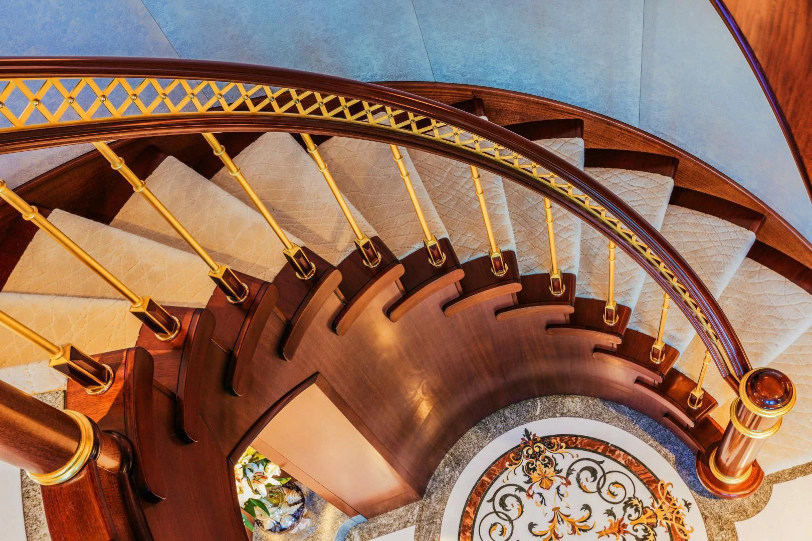a spiral staircase with gold trim aboard STARSHIP Yacht for Charter