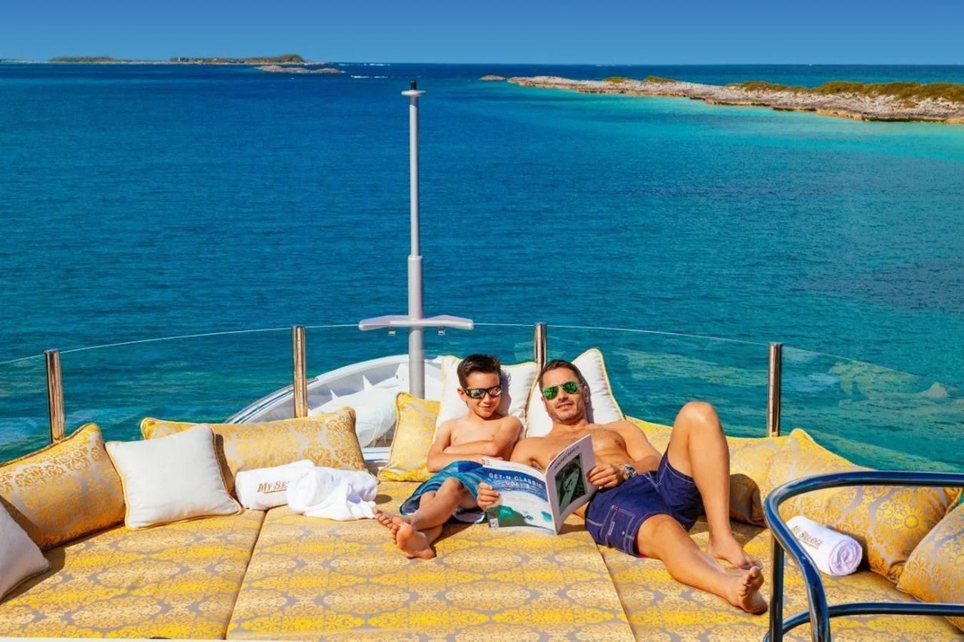 a group of people sitting on a lounge chair on a beach aboard STARSHIP Yacht for Charter