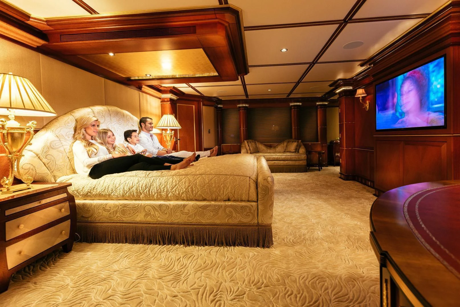 a group of people sitting on a couch watching television aboard STARSHIP Yacht for Charter