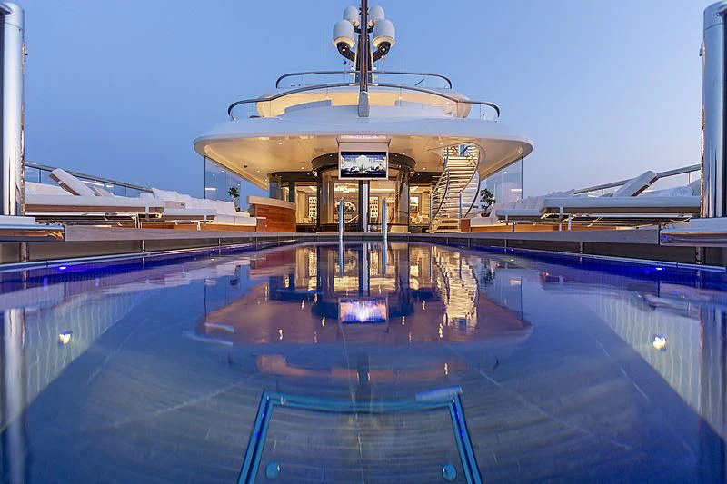 a swimming pool with a building in the background aboard LUNASEA Yacht for Sale