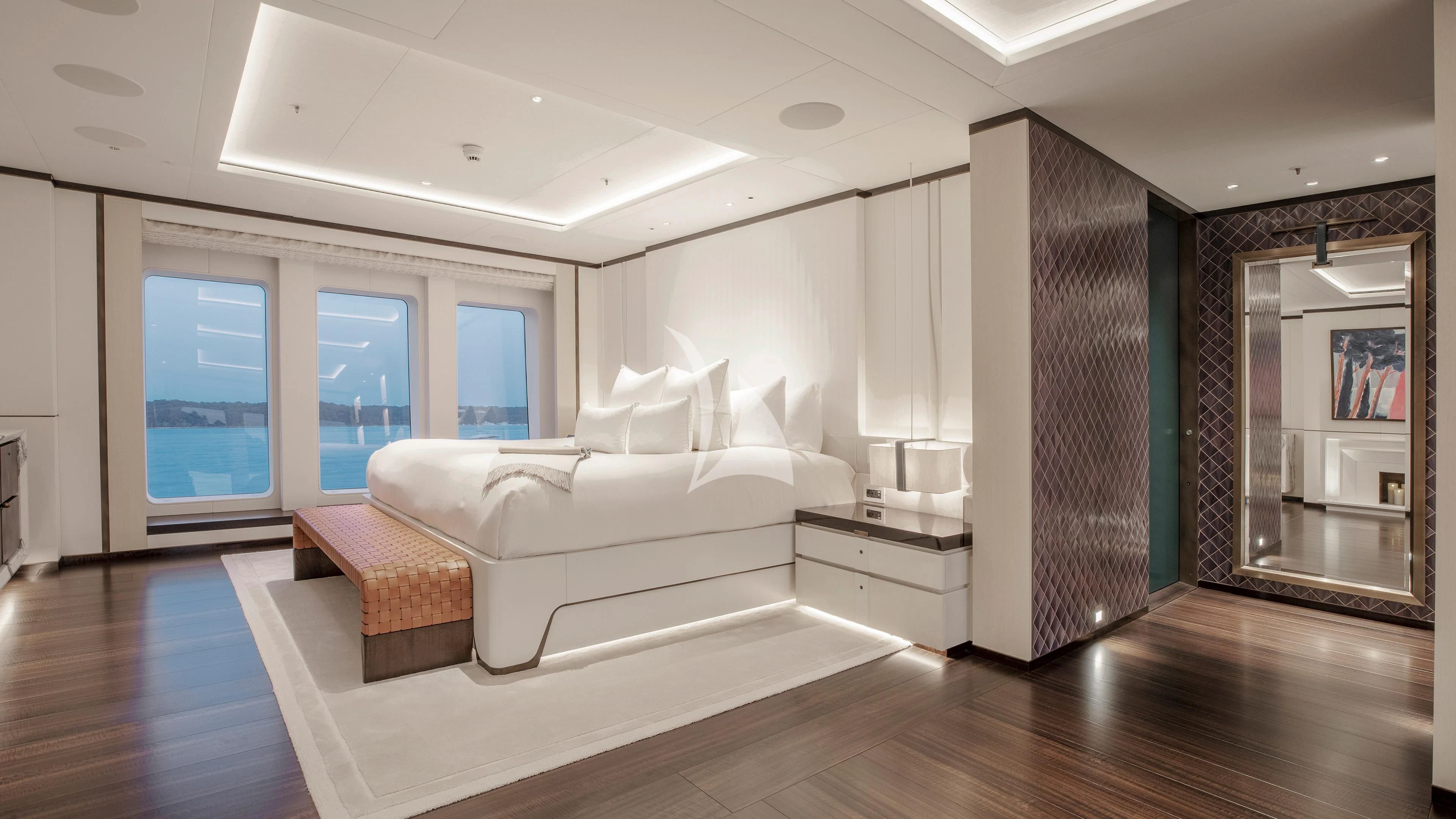 a large white room with a wood floor and a large mirror aboard LUNASEA Yacht for Sale