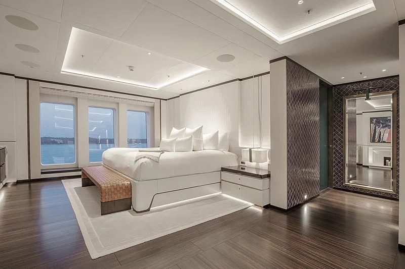 a large living room with a large white sofa and a wood floor aboard LUNASEA Yacht for Sale