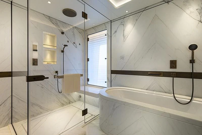 a bathroom with a shower and tub aboard LUNASEA Yacht for Sale