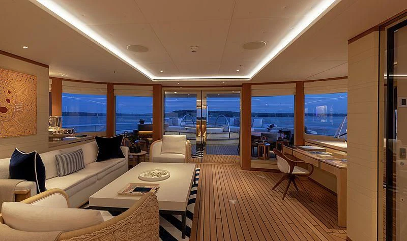 a room with a large window and a table with chairs and a view of the city aboard LUNASEA Yacht for Sale
