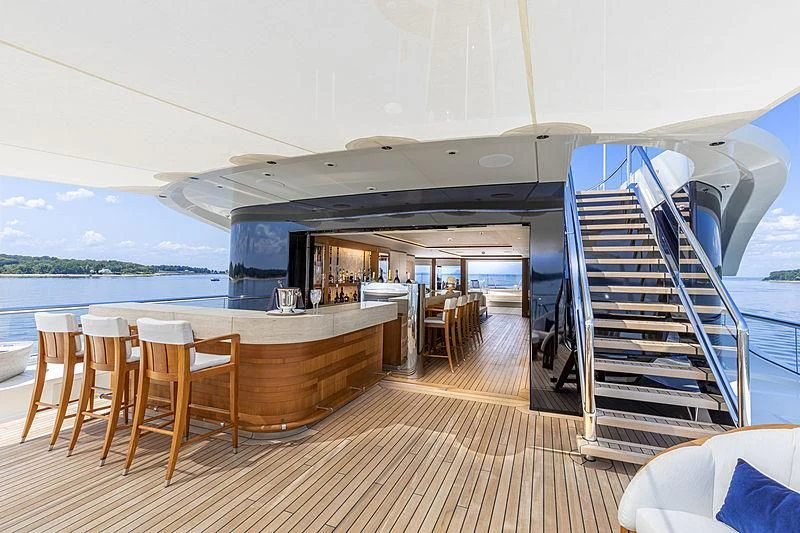 a deck with a table and chairs on it aboard LUNASEA Yacht for Sale
