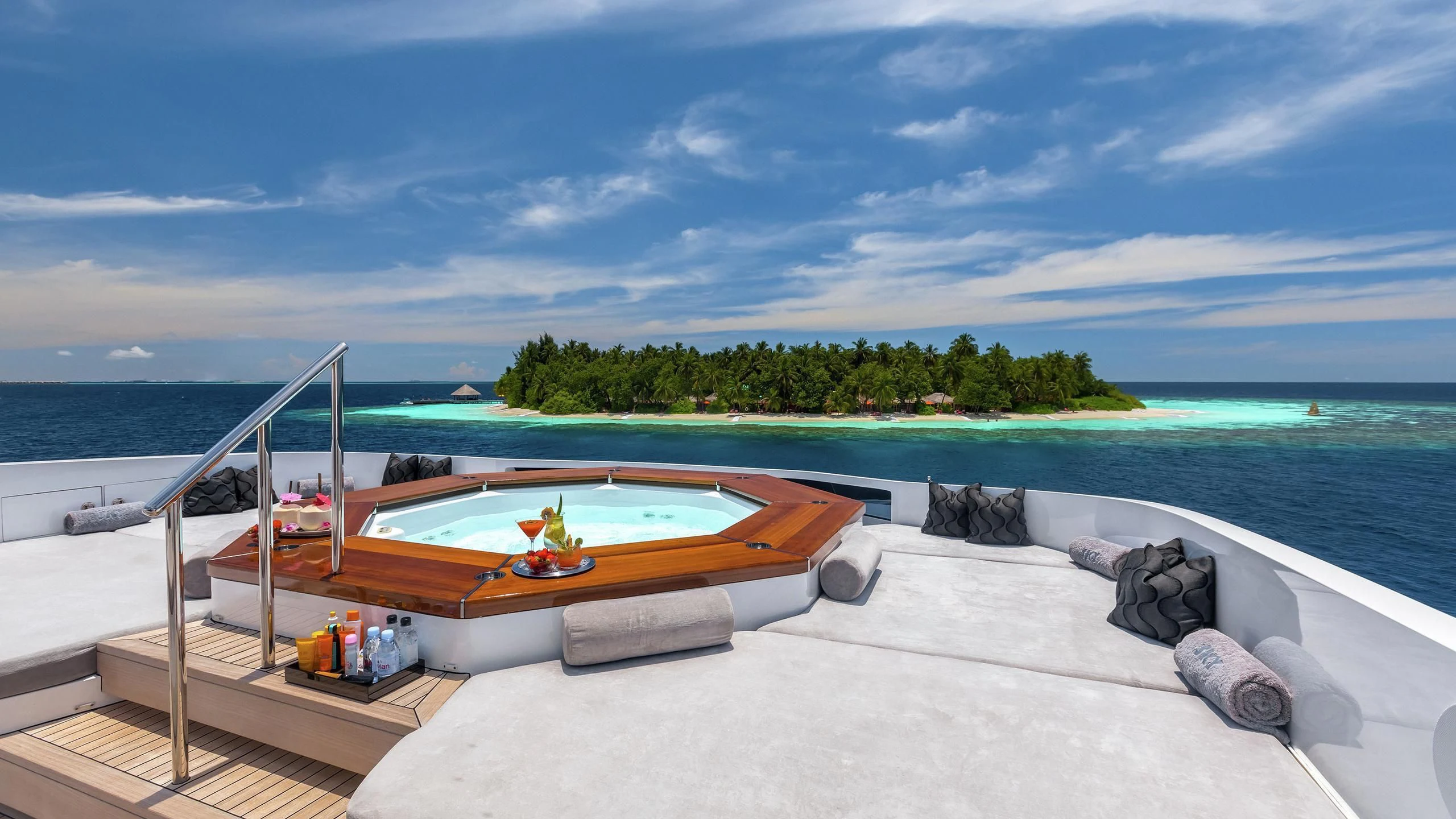 a pool on a deck overlooking a beach aboard TOTEM Yacht for Sale