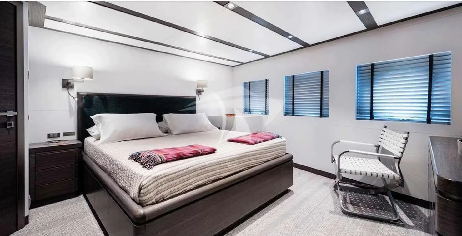 a bedroom with a bed and a chair aboard GENESIA Yacht for Sale