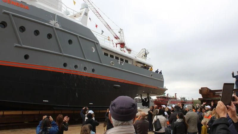 a large group of people standing next to a large ship aboard GENESIA Yacht for Sale