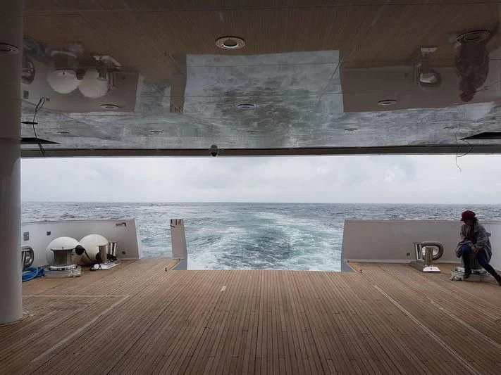 a person sitting on a deck looking out to the water aboard GENESIA Yacht for Sale