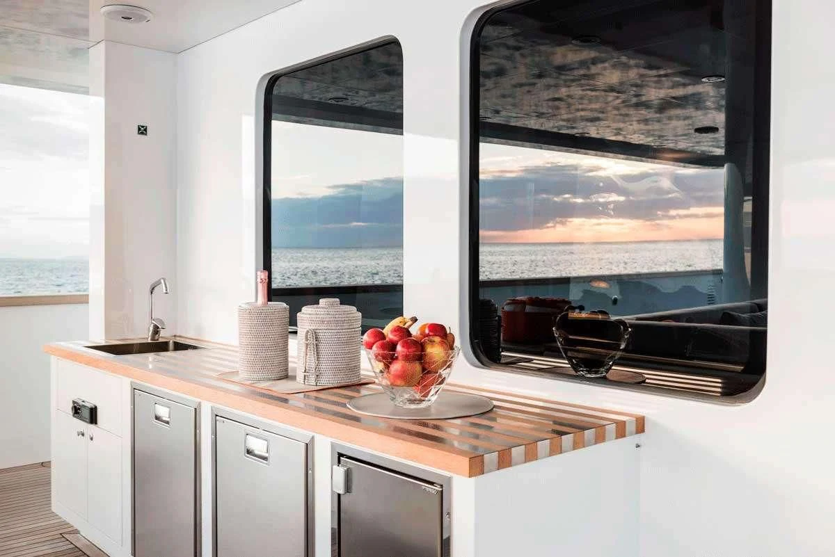 a kitchen with a large flat screen television and white cabinets aboard GENESIA Yacht for Sale