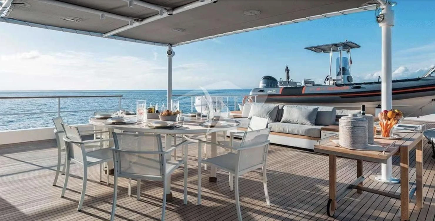 a table and chairs on a deck aboard GENESIA Yacht for Sale