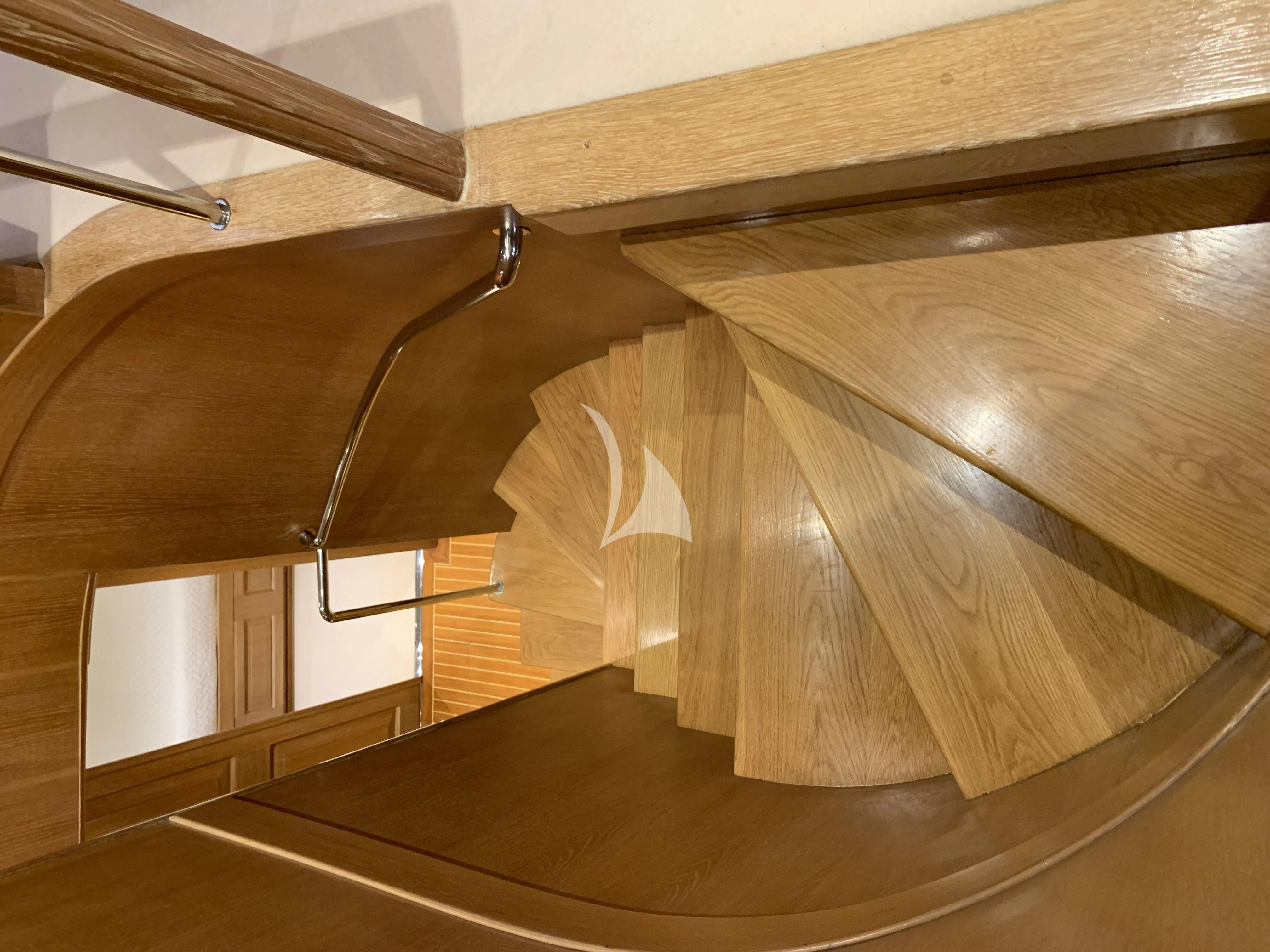 a wooden staircase with a spiral staircase aboard ALTHEA Yacht for Sale