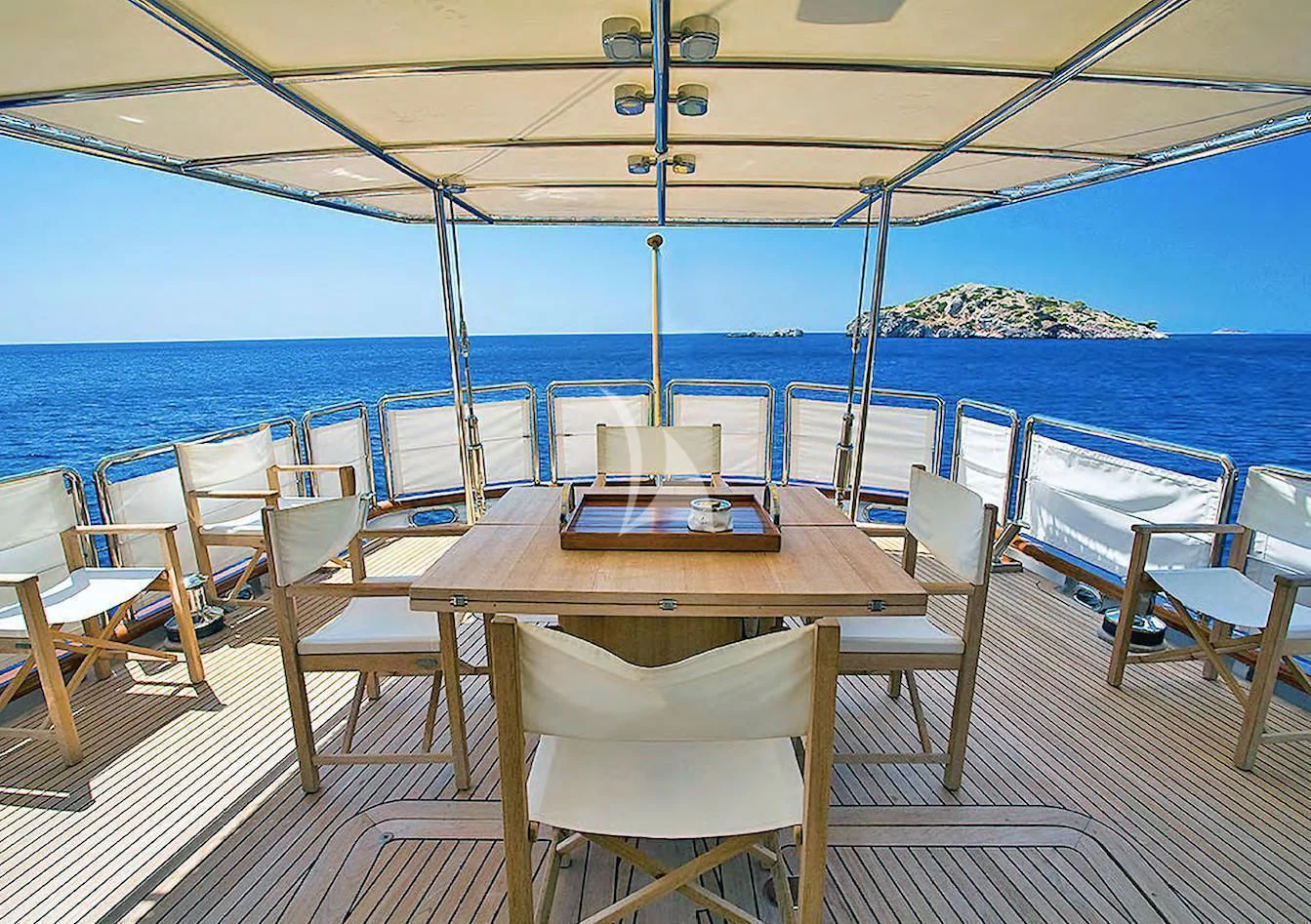 a table set on a deck overlooking the ocean aboard ALTHEA Yacht for Sale