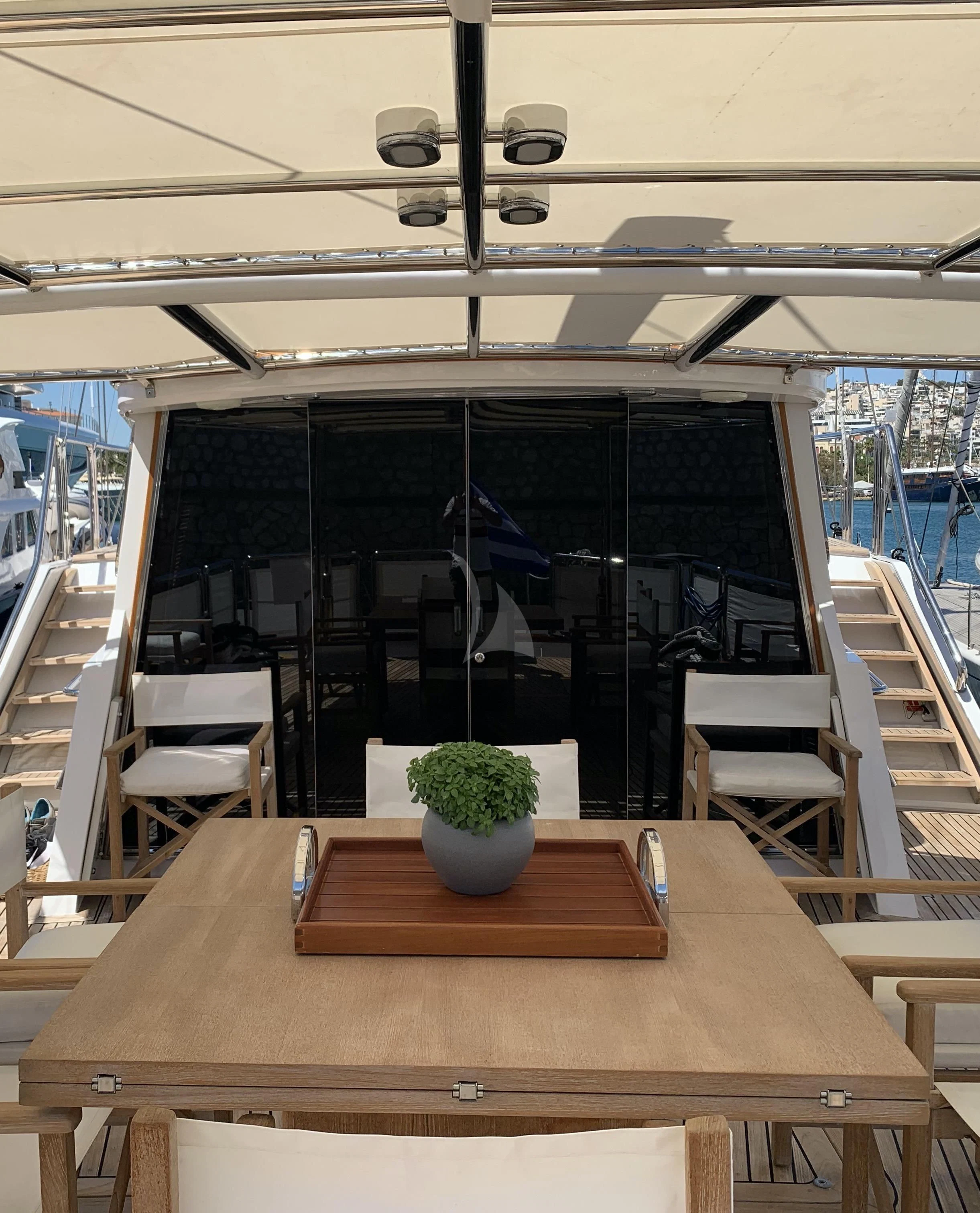 a table with chairs and plants in a room with glass walls aboard ALTHEA Yacht for Sale