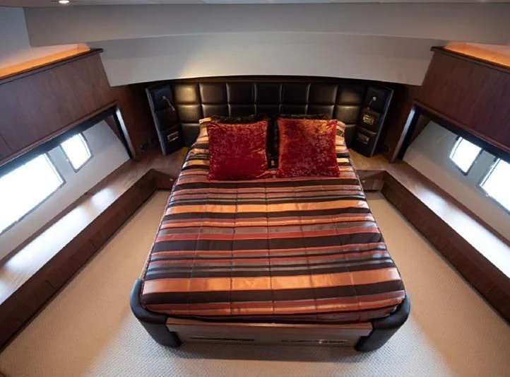 a bed with a red pillow aboard BARBIZON Yacht for Sale