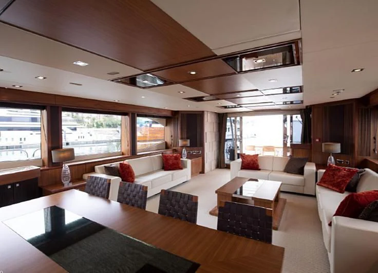 a living room with a large table and couches aboard BARBIZON Yacht for Sale