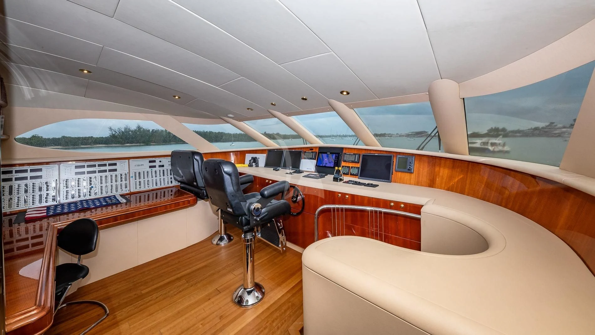 a room with a couch and a table with chairs and a large window aboard TRANQUILITY IV Yacht for Sale