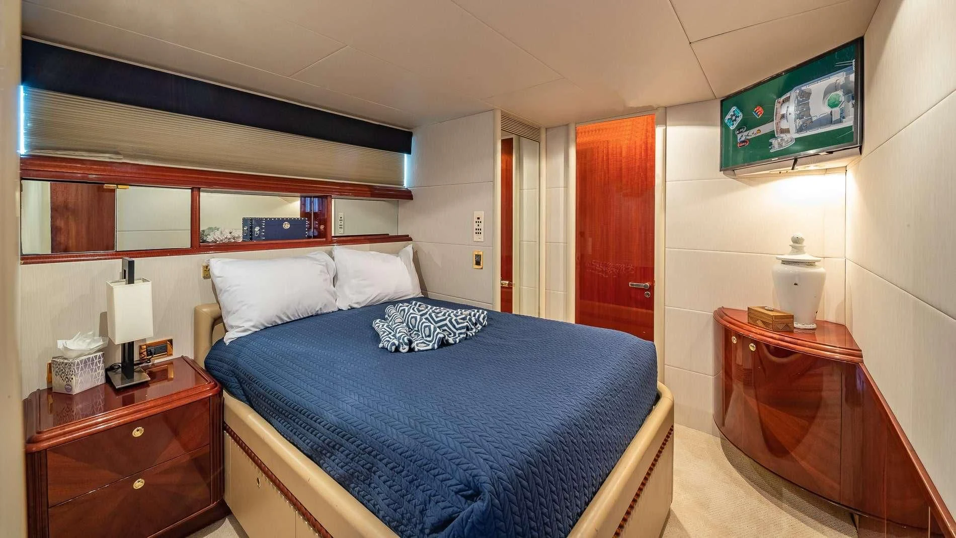 a bedroom with a bed and dresser aboard TRANQUILITY IV Yacht for Sale