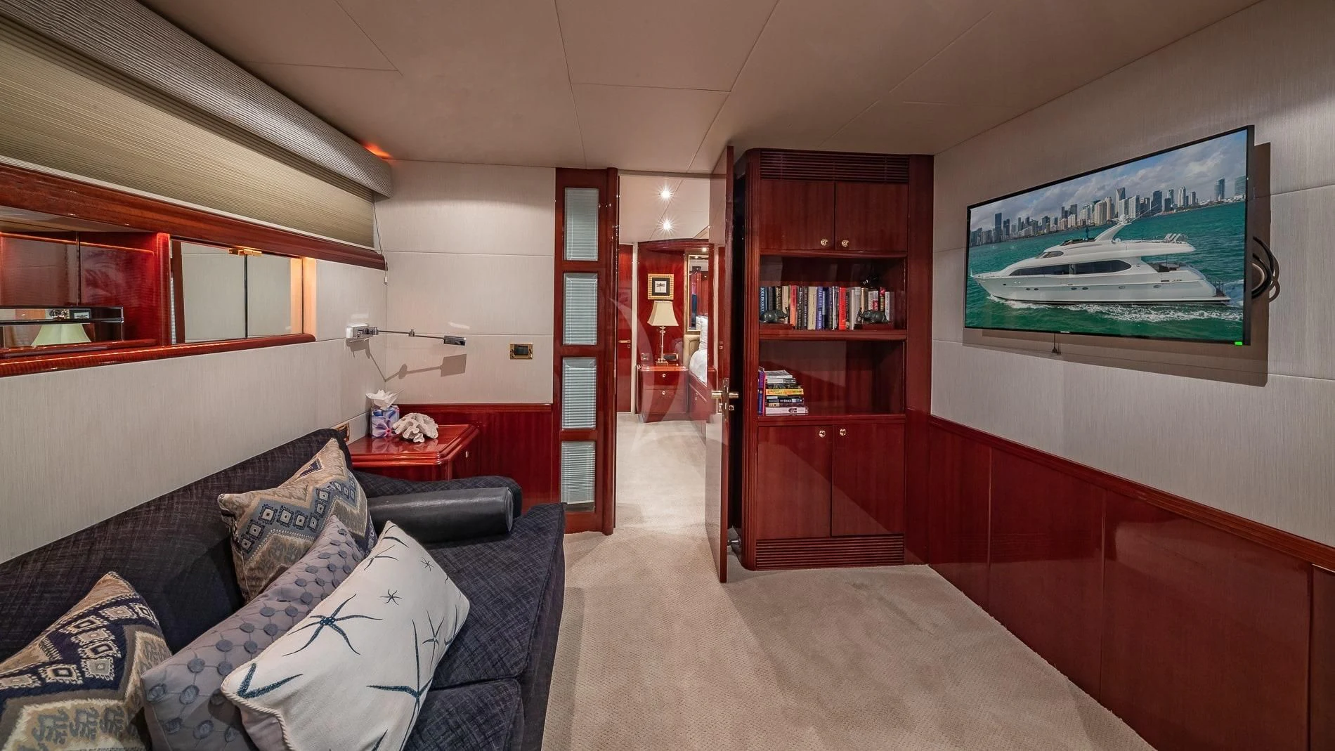 a bedroom with a bed and a bookcase aboard TRANQUILITY IV Yacht for Sale