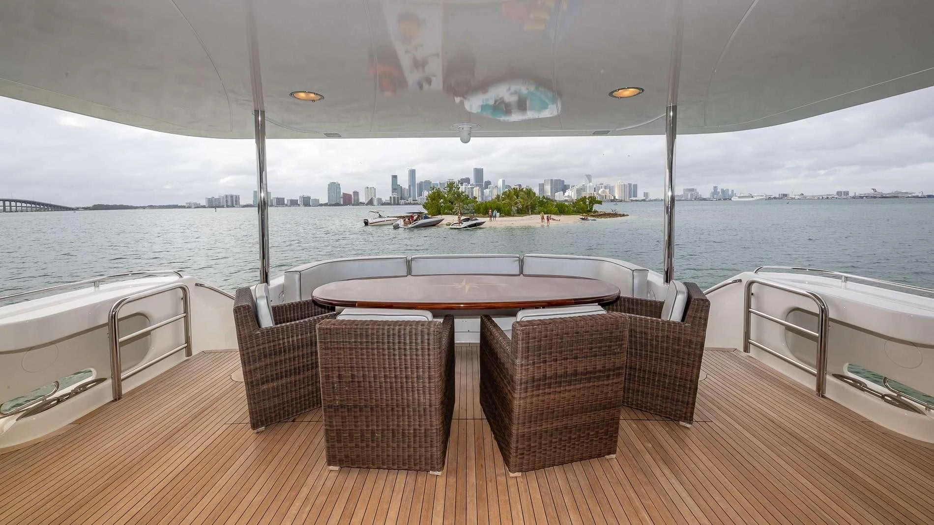 a table and chairs on a deck overlooking a body of water aboard TRANQUILITY IV Yacht for Sale