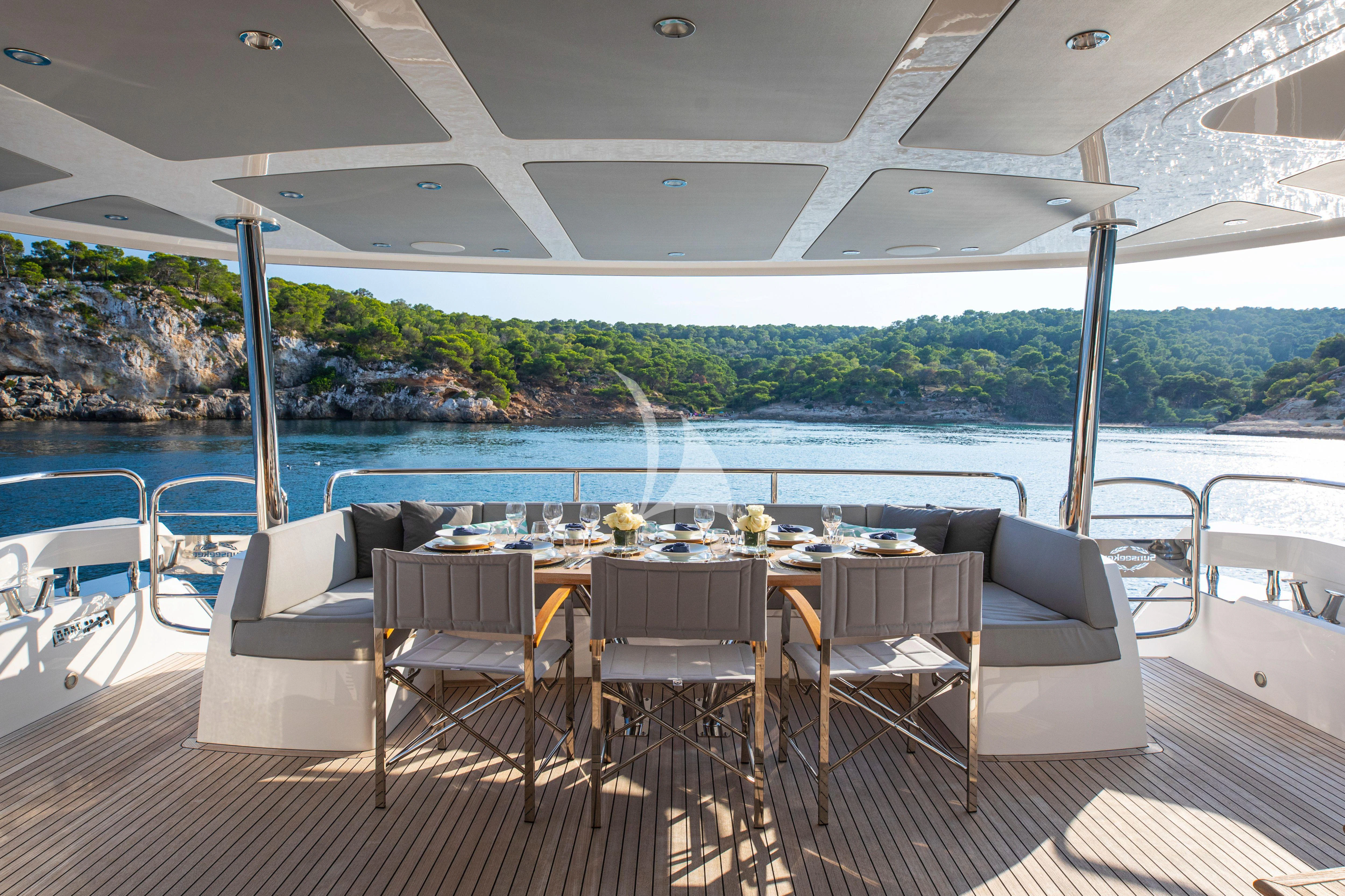 a table and chairs on a deck overlooking a large body of water aboard RUSH X Yacht for Sale