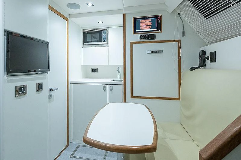 a bathroom with a toilet and a tv on the wall aboard RUSH X Yacht for Sale