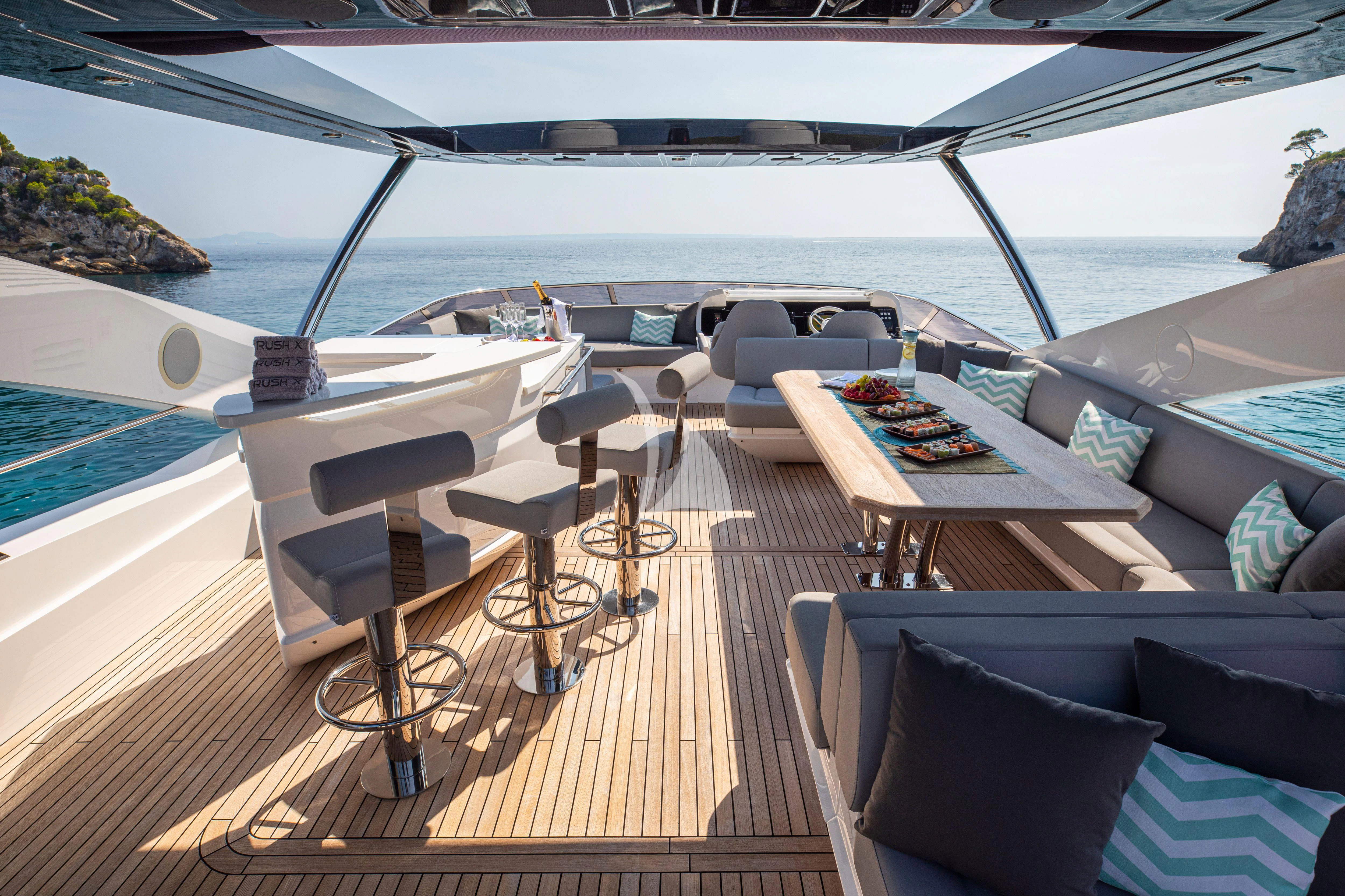 a deck with a table and chairs on it aboard RUSH X Yacht for Sale