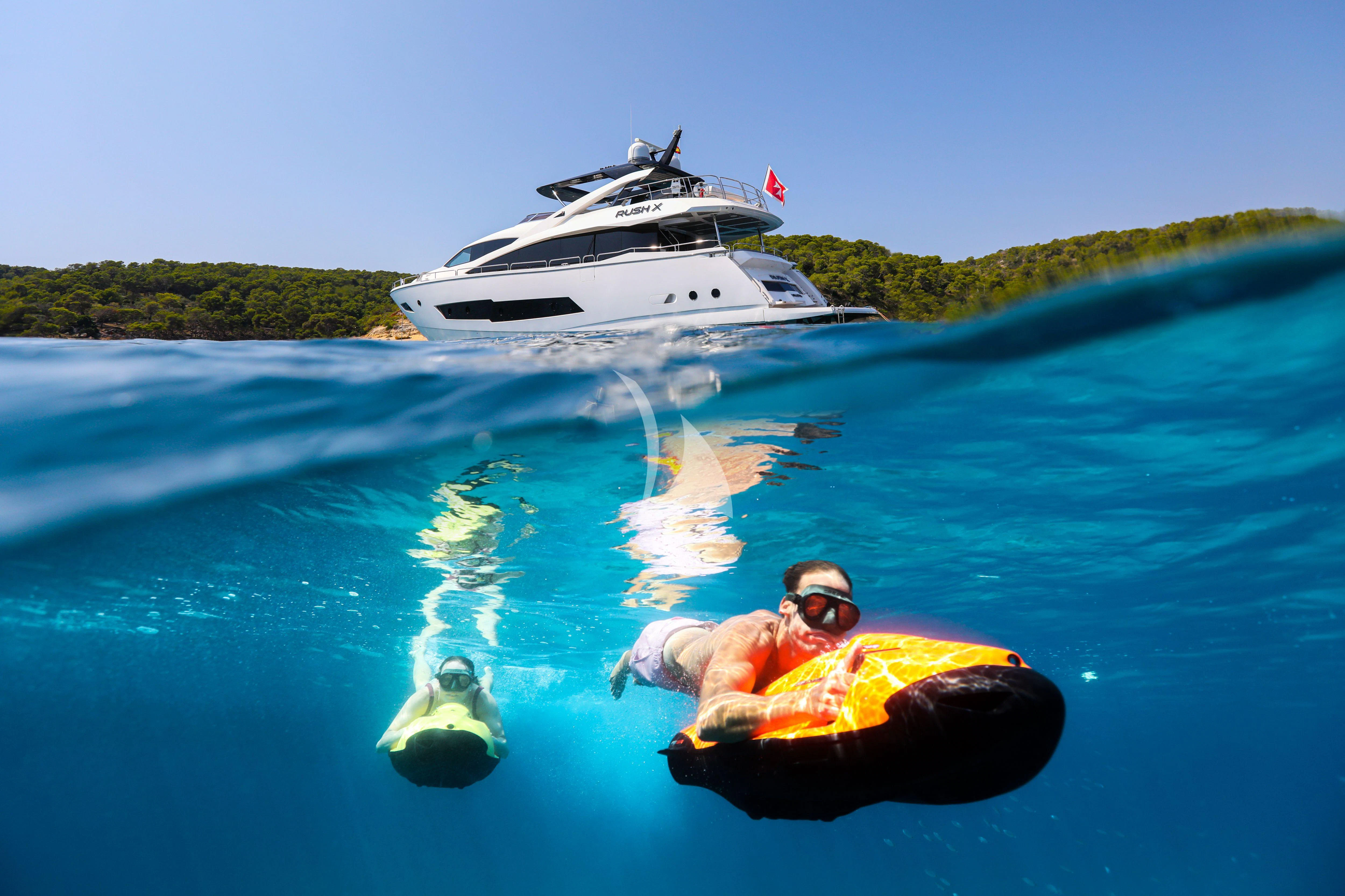 a person floating on a raft in the water with a boat in the background aboard RUSH X Yacht for Sale