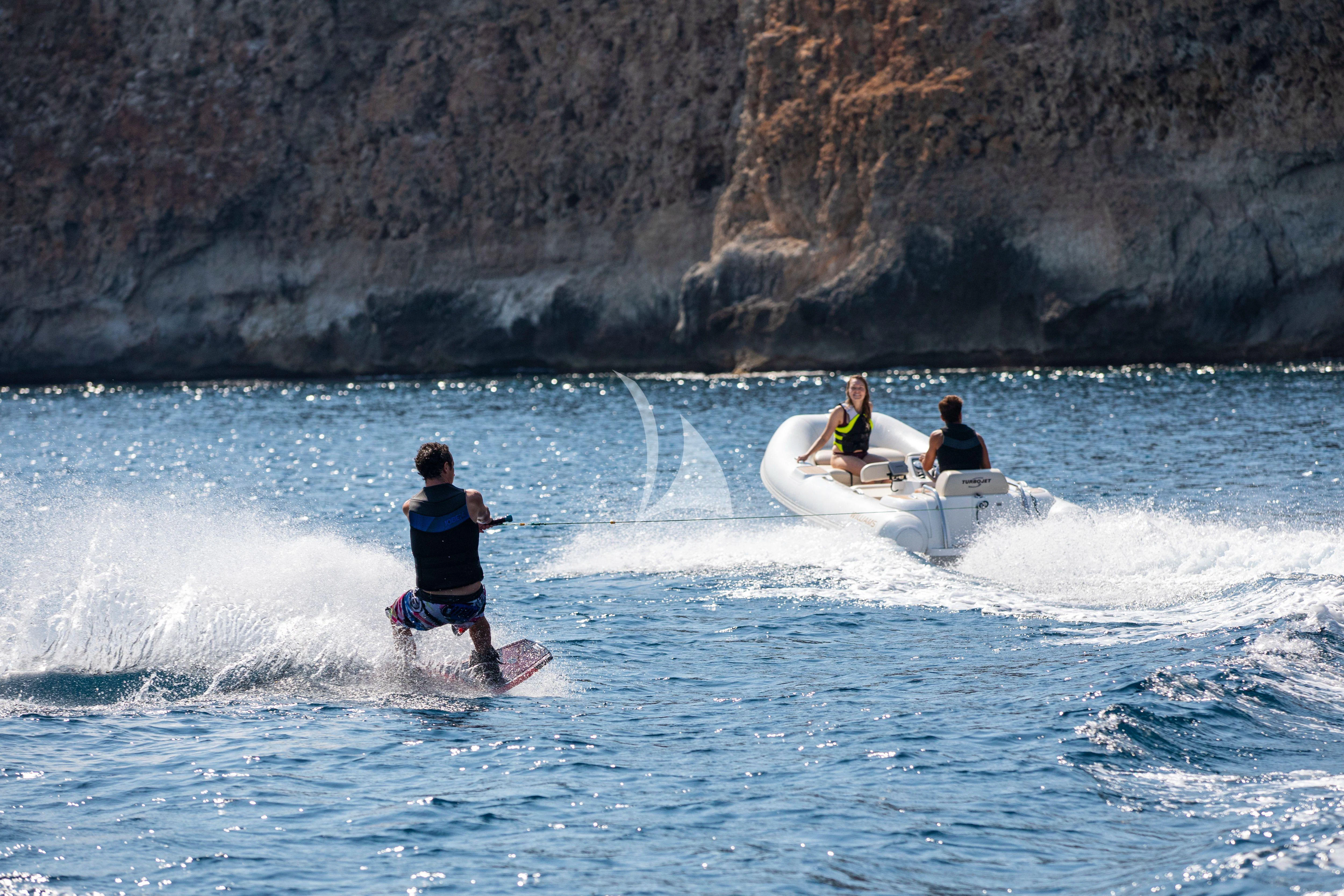 a group of people riding surfboards aboard RUSH X Yacht for Sale