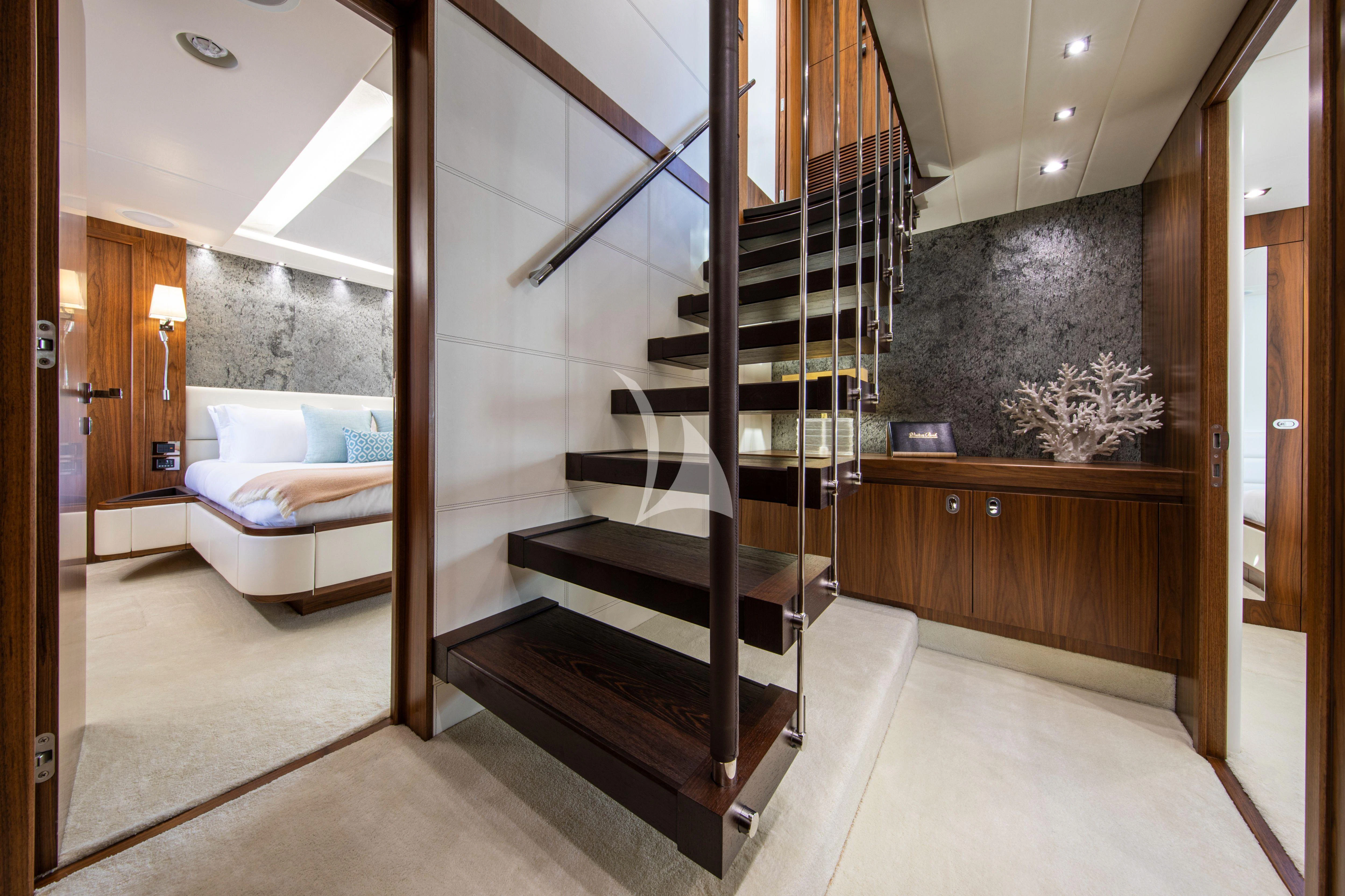 a large black and white staircase in a room with a bed and a couch aboard RUSH X Yacht for Sale