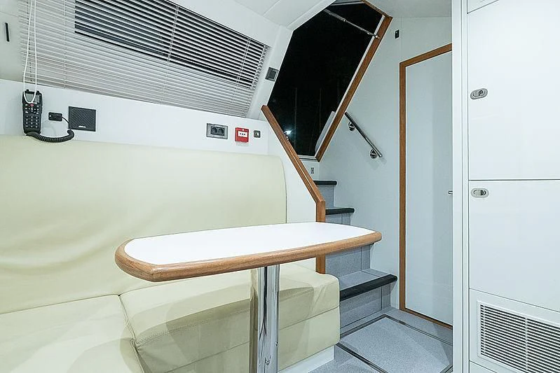 a room with a table and a bench aboard RUSH X Yacht for Sale