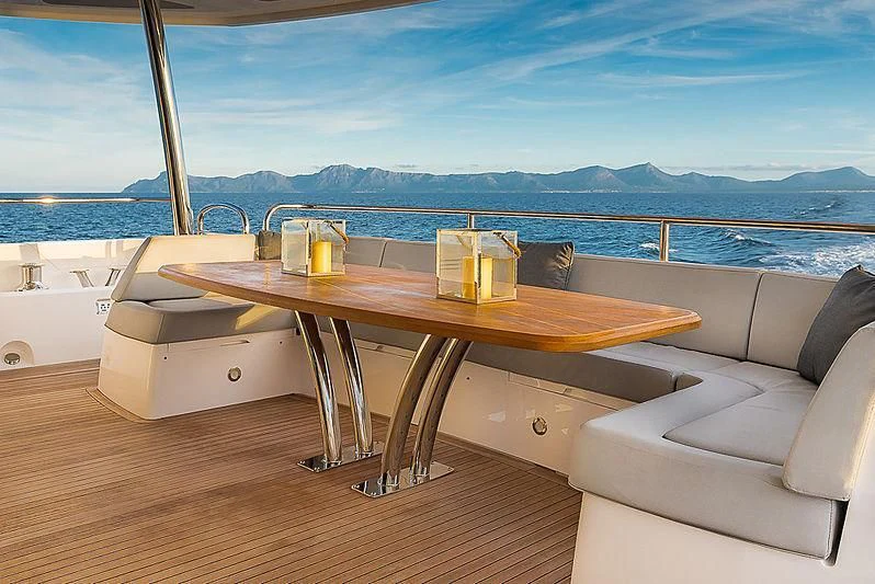 a table on a deck overlooking a body of water aboard RUSH X Yacht for Sale