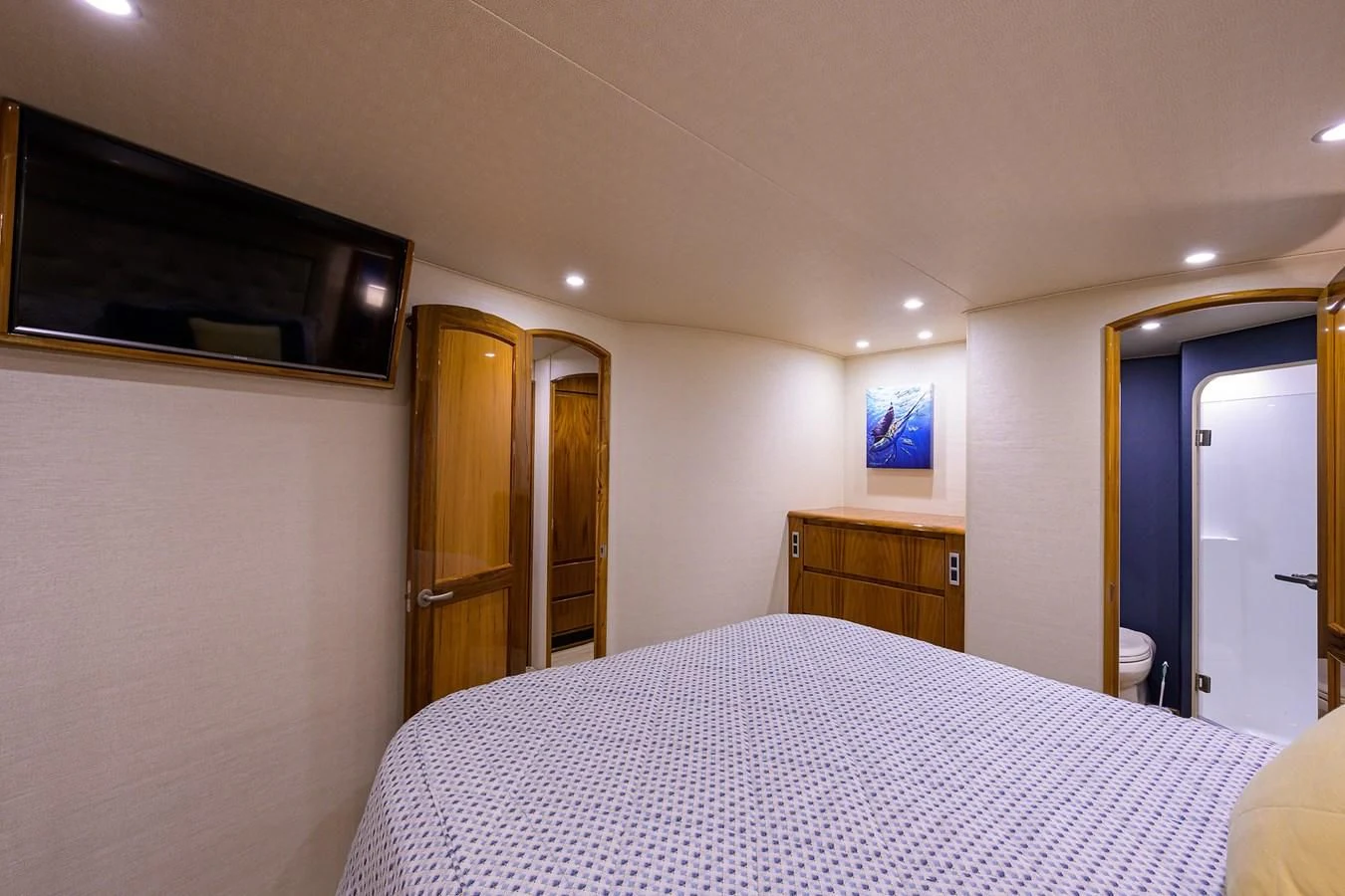 a bedroom with a bed and a television on the wall aboard TORO Yacht for Sale