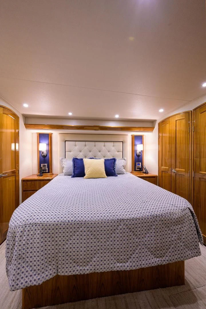 a bed with a blue and white comforter aboard TORO Yacht for Sale