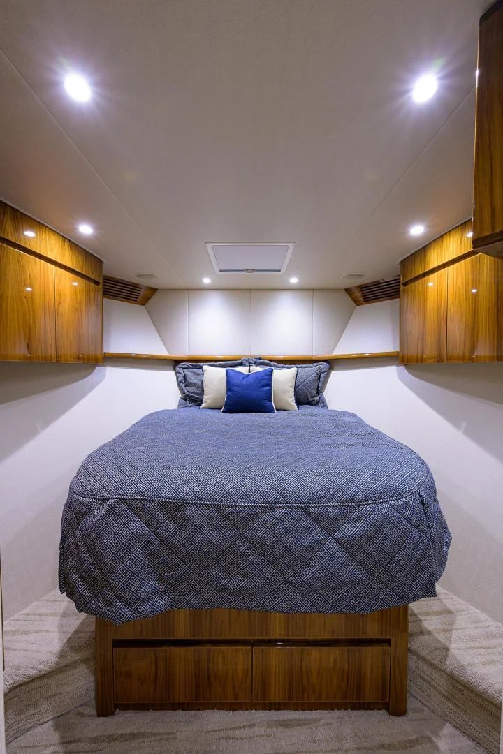 a bed with a blue blanket aboard TORO Yacht for Sale
