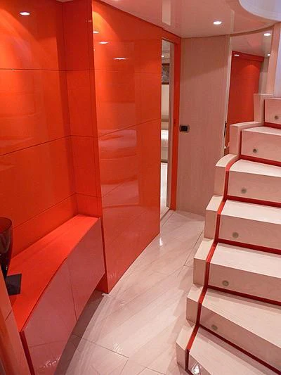 a room with a wood floor and a red wall with white cabinets aboard SOFIA Y Yacht for Sale