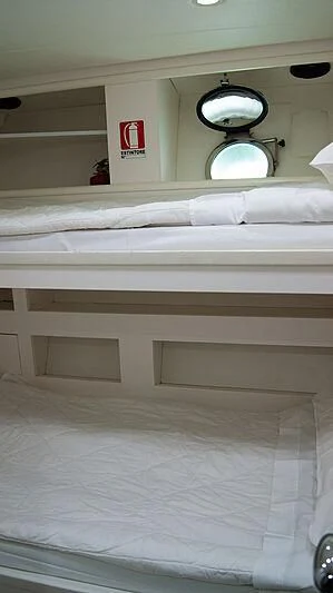 a white bed with a red sign above it aboard SOFIA Y Yacht for Sale