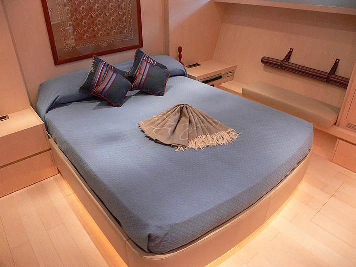 a bed with a blue comforter aboard SOFIA Y Yacht for Sale