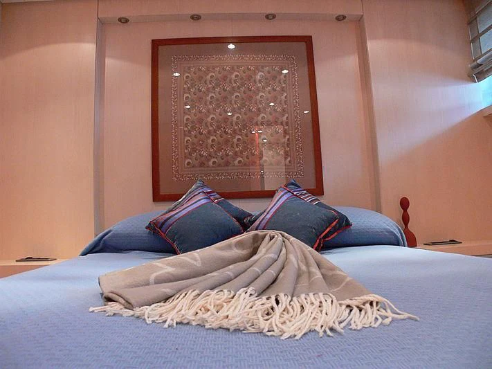 a bed with a blue pillow aboard SOFIA Y Yacht for Sale