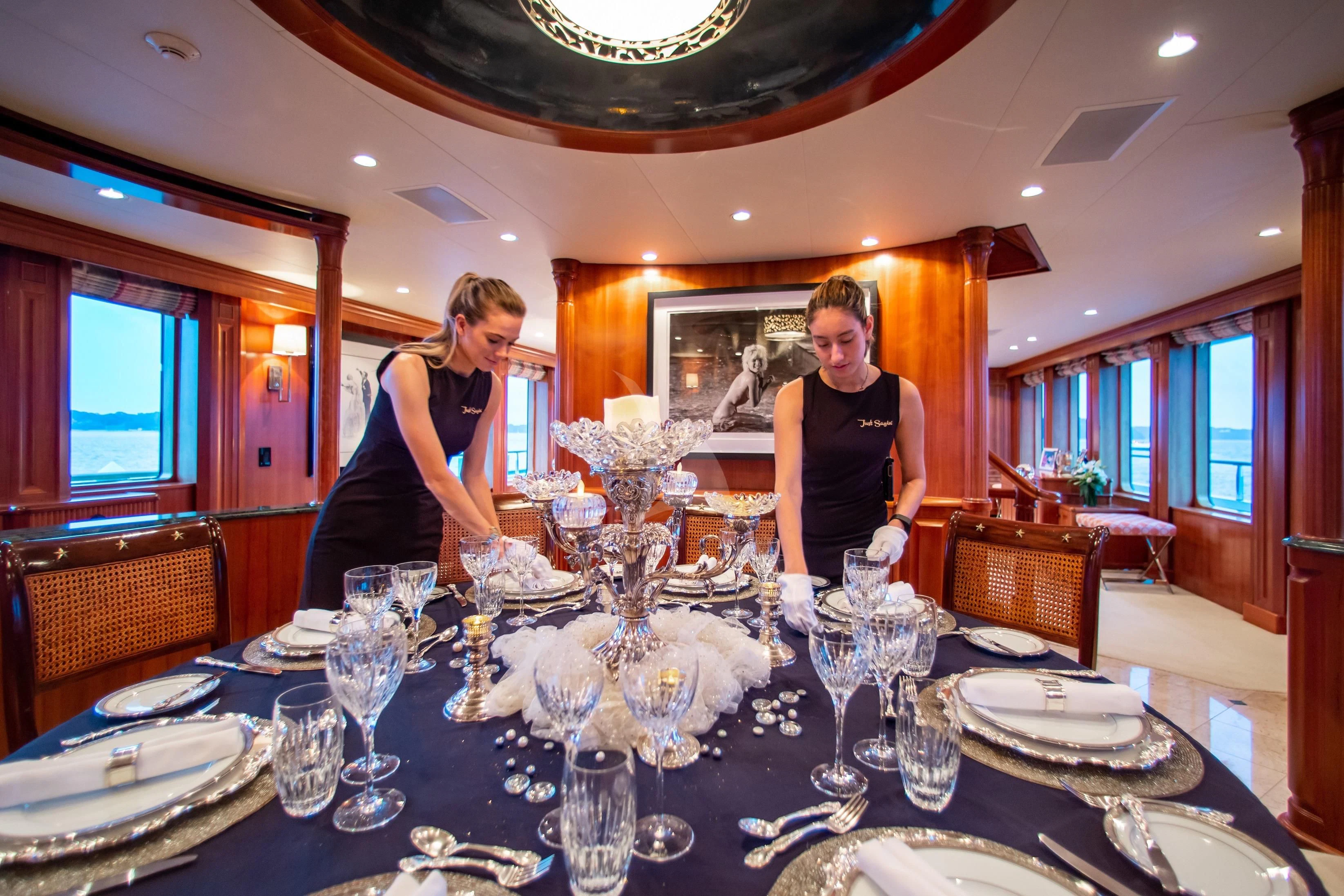 a couple of women sitting at a table with plates and silverware aboard PACKAGE DEAL Yacht for Charter