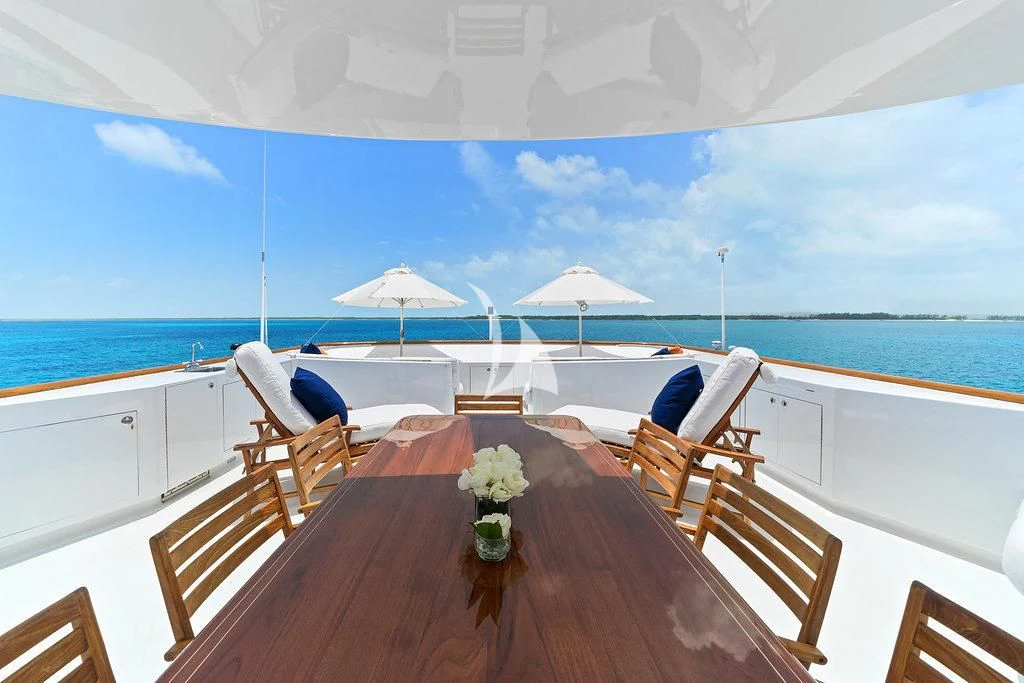 a table with chairs on it next to a body of water aboard PACKAGE DEAL Yacht for Charter