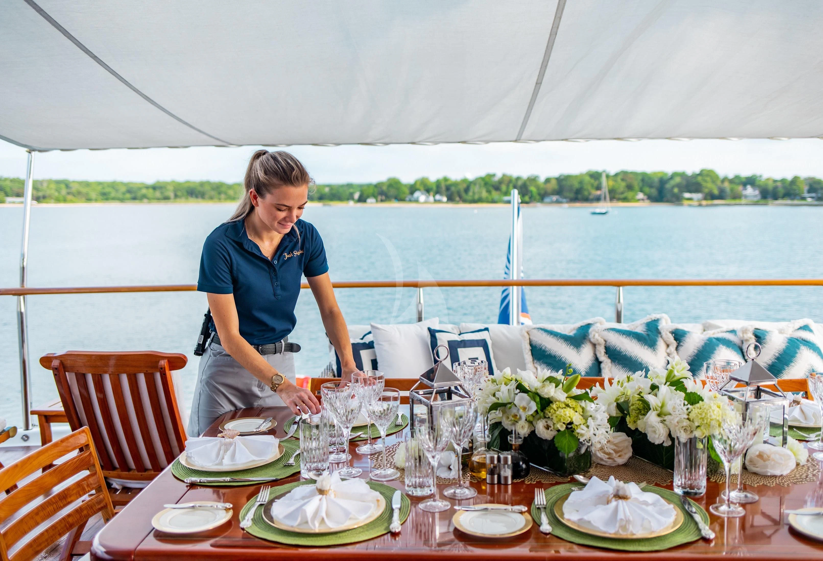a person pouring wine into a glass aboard PACKAGE DEAL Yacht for Charter