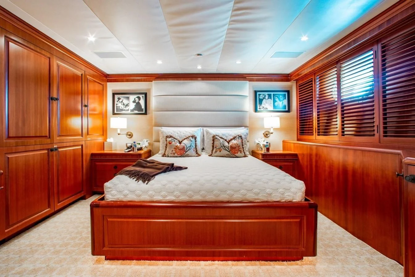 a bedroom with a bed and a wood cabinet aboard PACKAGE DEAL Yacht for Charter