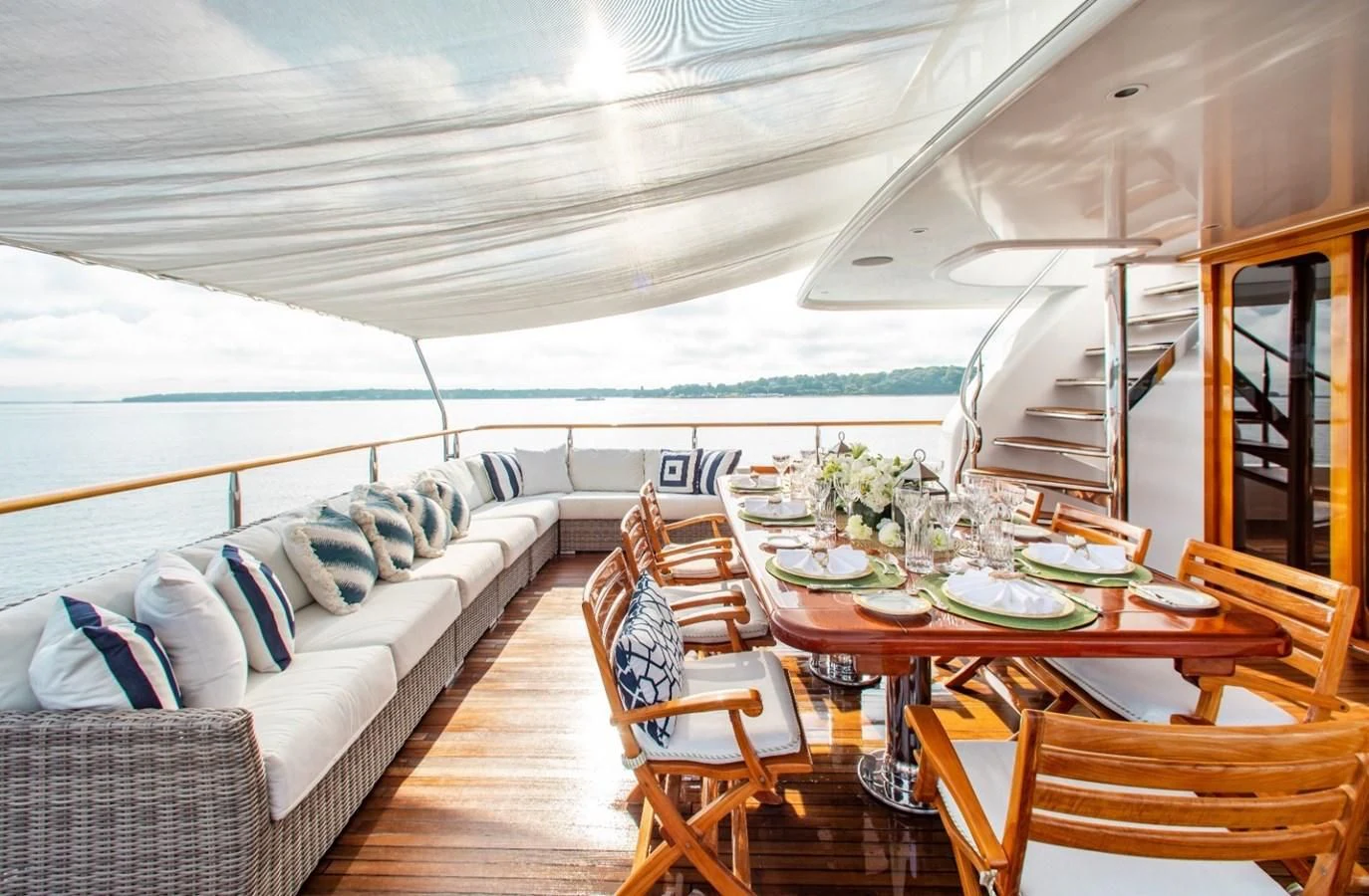 a large living room with a large patio and dining table aboard PACKAGE DEAL Yacht for Charter