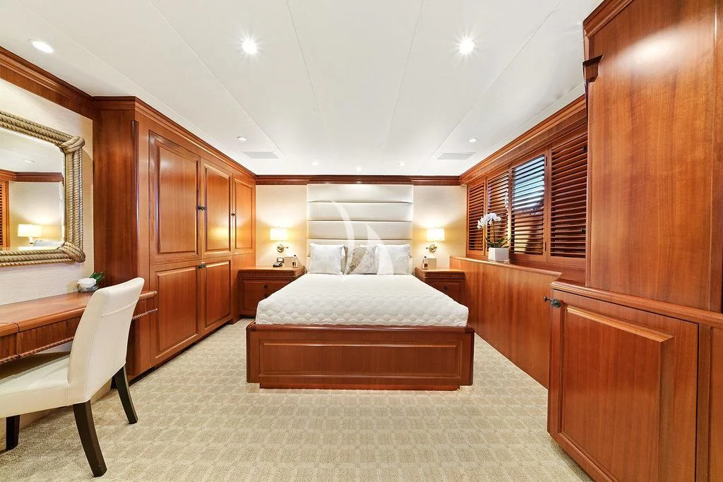 a bedroom with a bed and a chair aboard PACKAGE DEAL Yacht for Charter